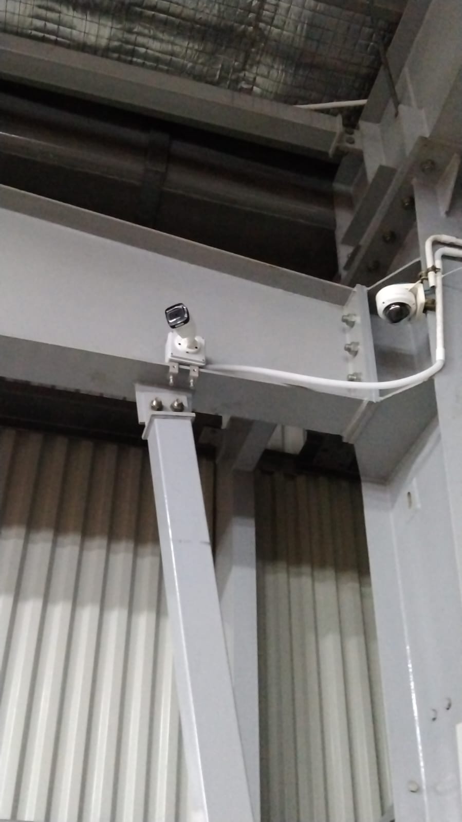 Instalasi CCTV di Area Gudang. Kamera CCTV terpasang pada struktur bangunan gudang.
